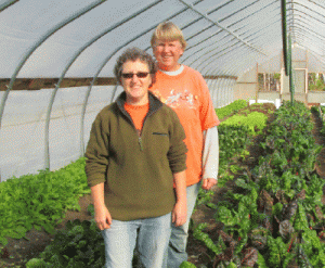 Debbie and Audrey showing off their vibrant Swiss chard in one of their hoophouses.  Photo by Lydia Johnson.