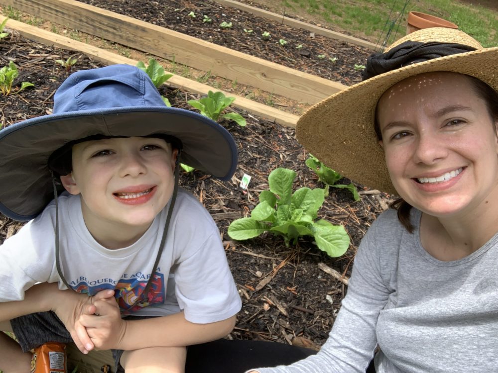 Marianna Spence and her son posing in front of their garden beds