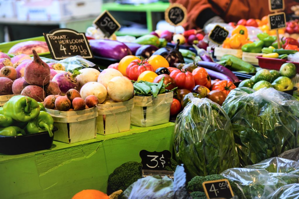 Colorful vegetables displayed in a farmers market stall.